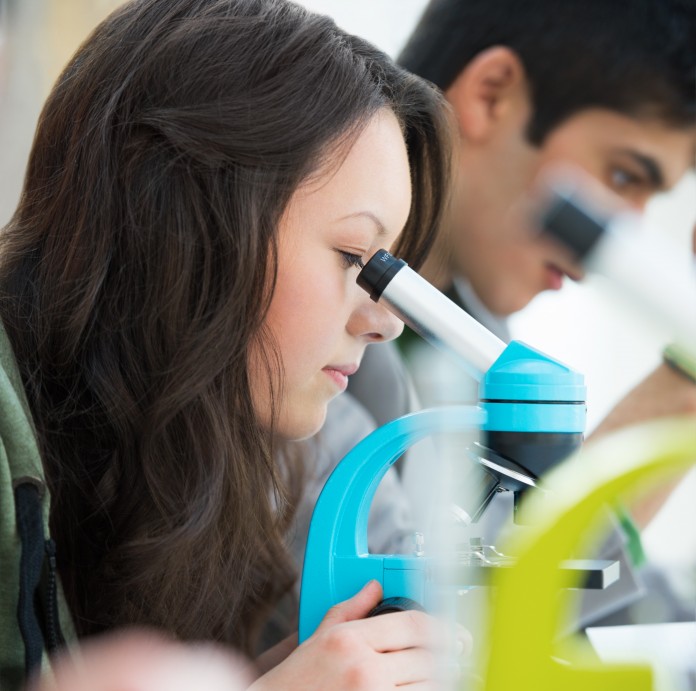 High School students. Young pretty girl student peering through Early College